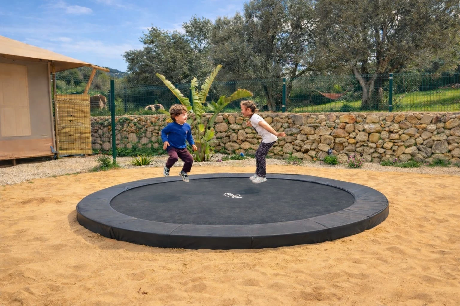 Kinderen op de ingegraven trampoline
